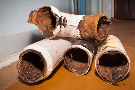 Pieces of cast iron pipes on a floor.