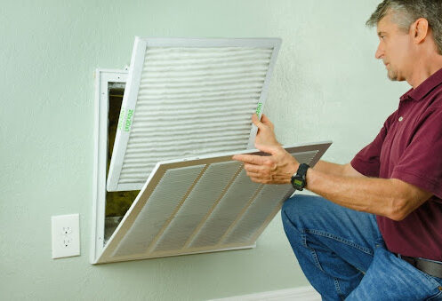 Homeowner changing air filter.