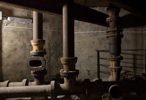 Old galvanized cast iron pipes in a basement.