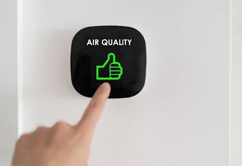 A finger pressing a button that says "air quality" with a thumbs up icon.